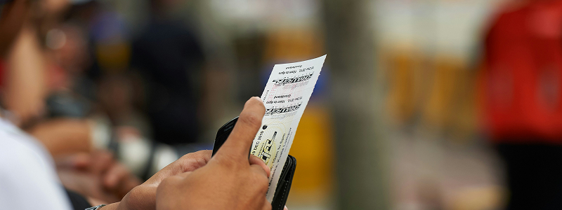 Person holding ticket being scanned at gate